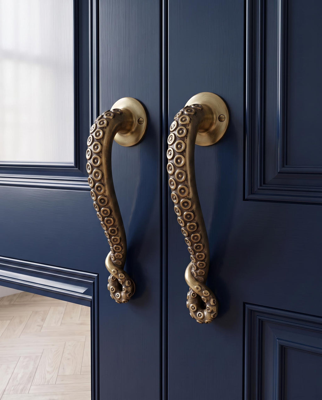 Two brass octopus tentacle door handles with suction cups on a navy blue double door