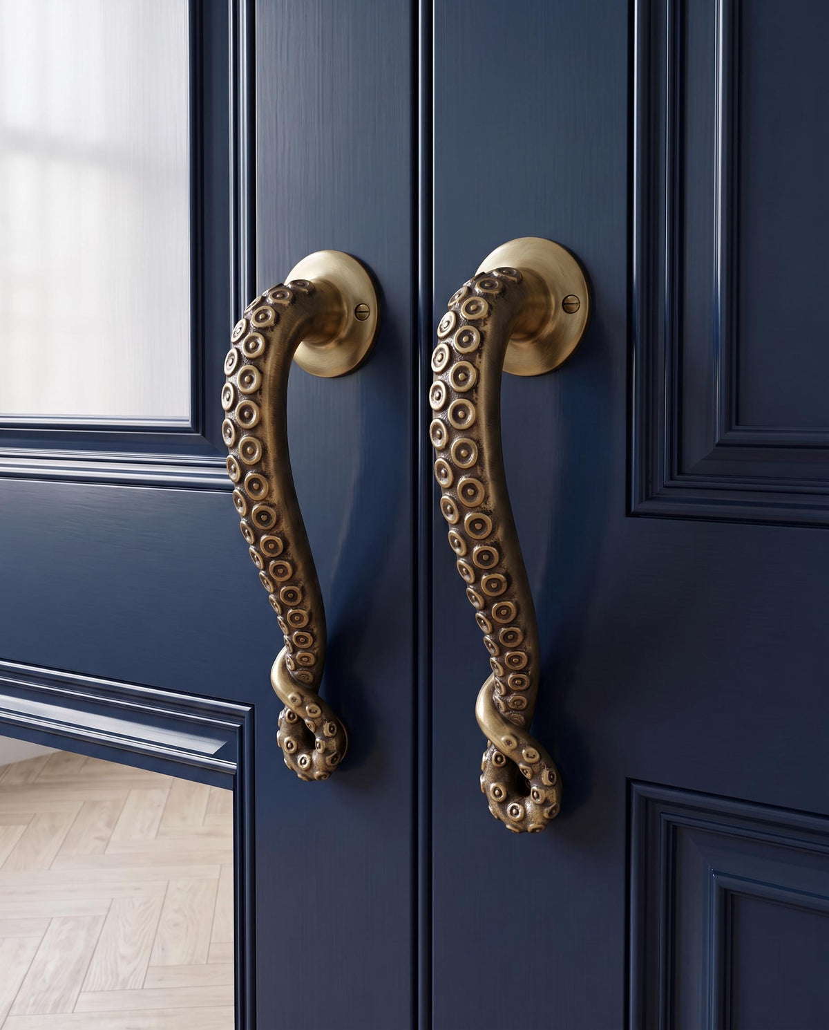Two brass octopus tentacle door handles with suction cups on a navy blue double door