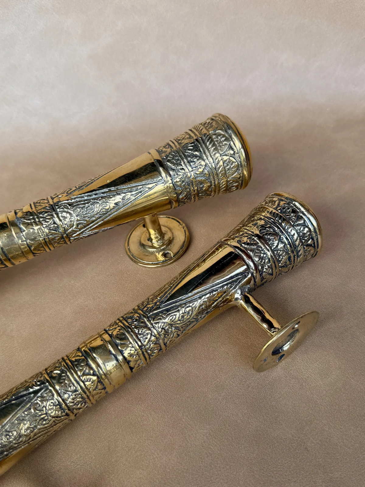 Close-up of the engraved pattern on two solid brass pull handles