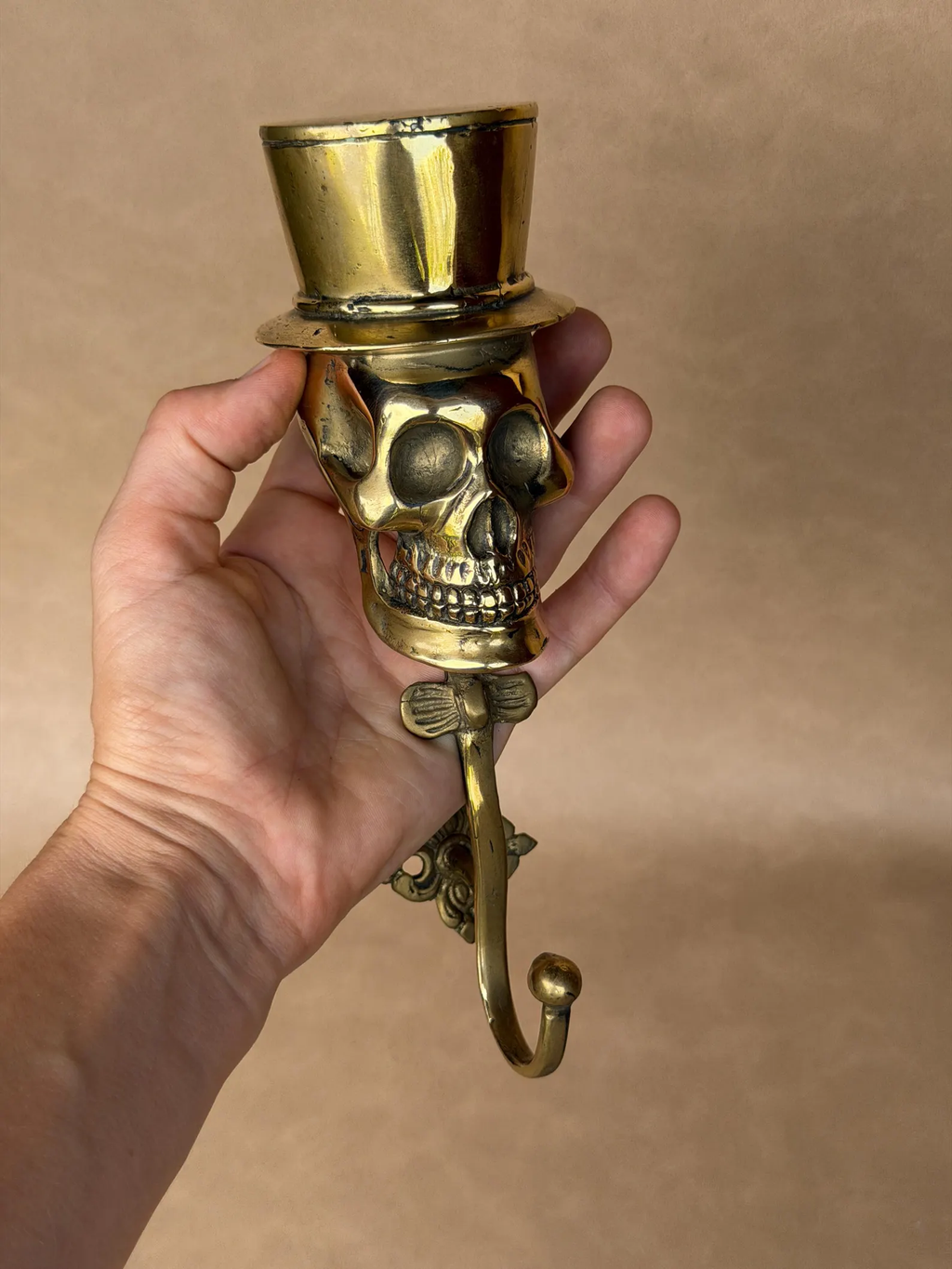 Front close-up of the sculpted brass skull face under a top hat