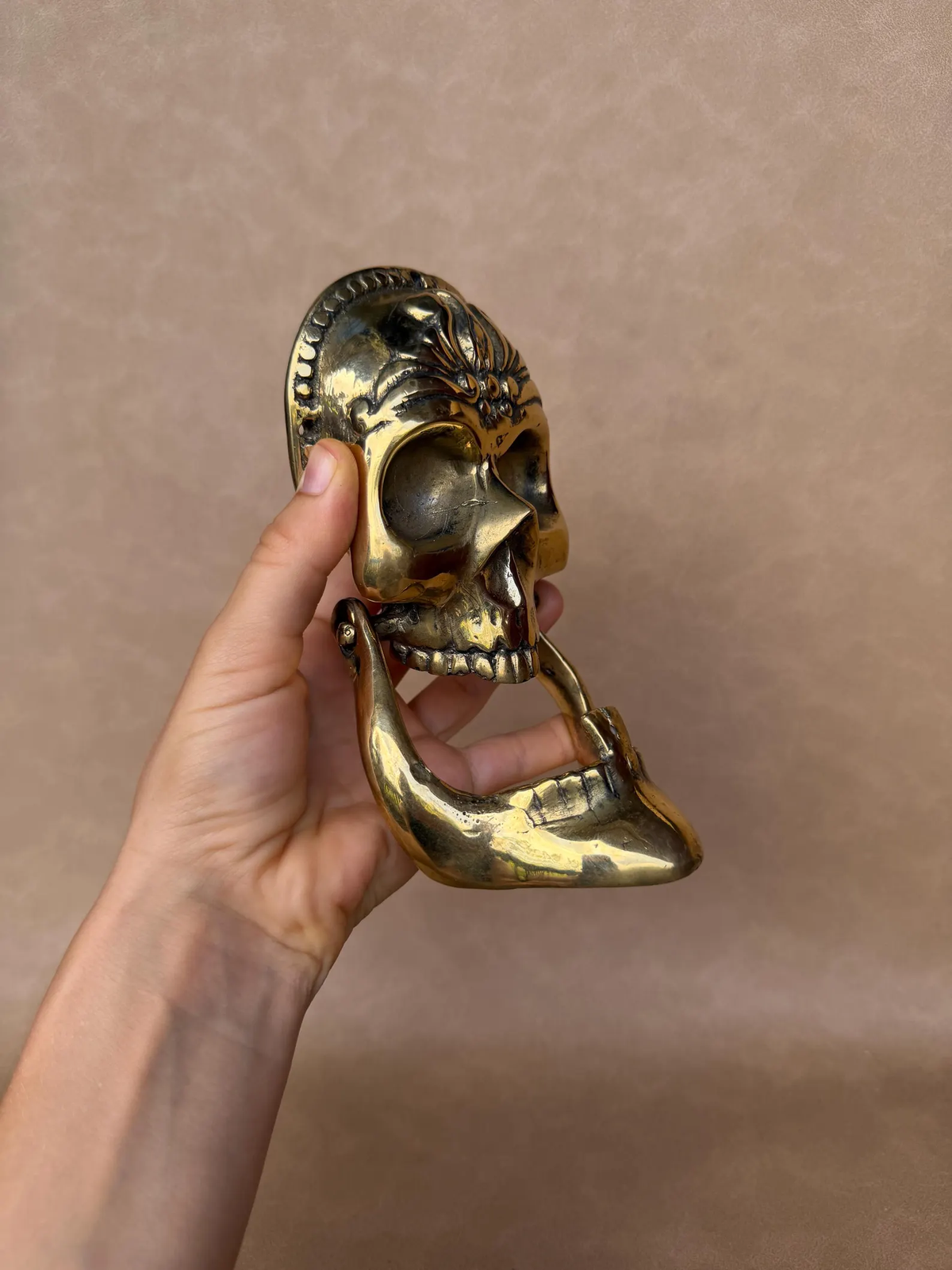 Close detail of sculpted skull and jaw on brass knocker