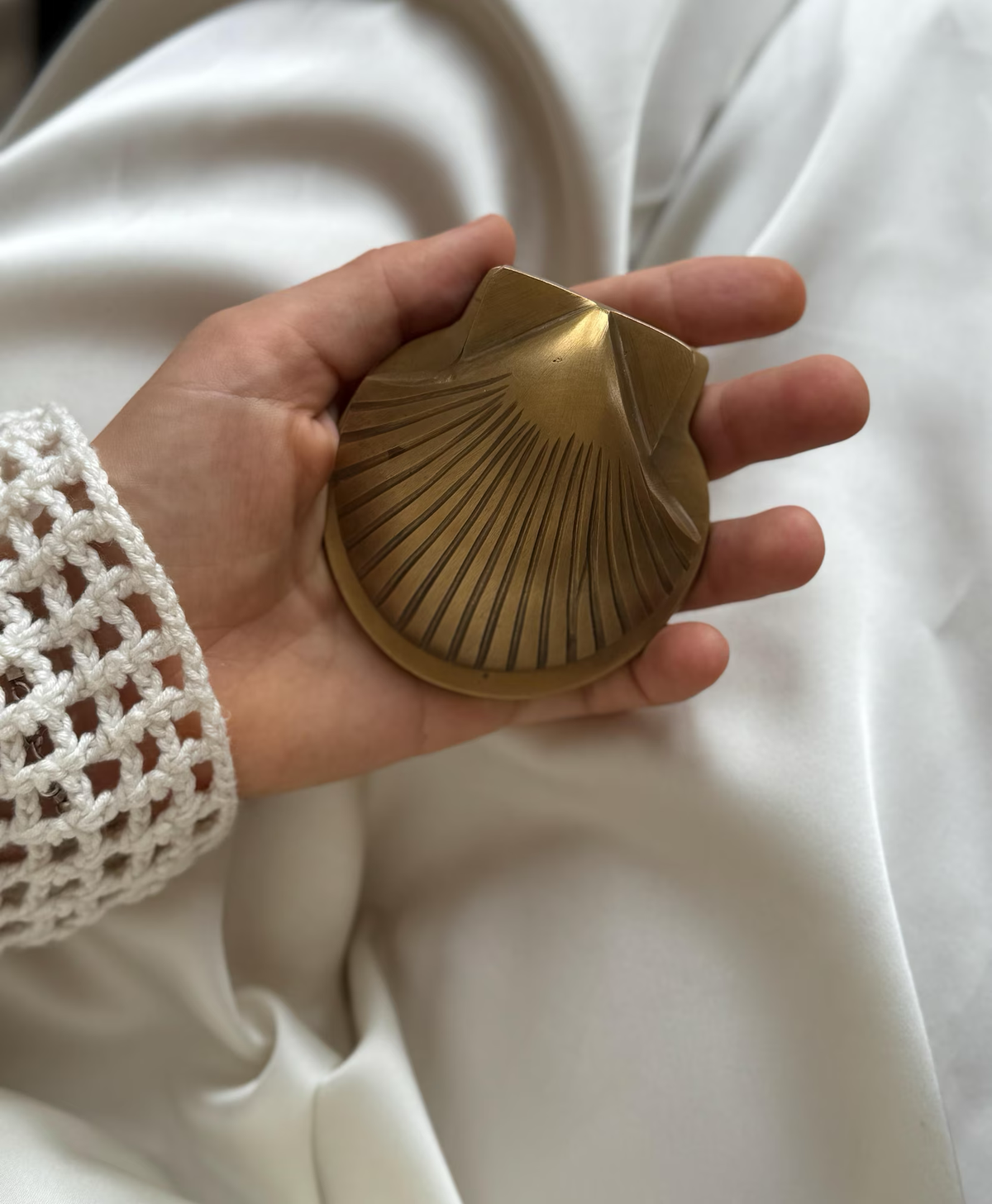 Brass shell clip resting in an open palm to show its size