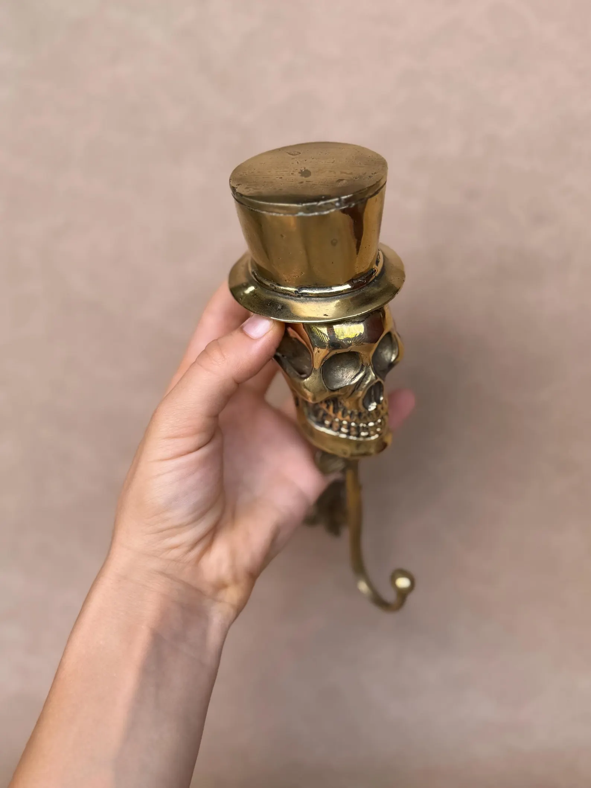 Brass top hat seen from above, with the skull and hook below