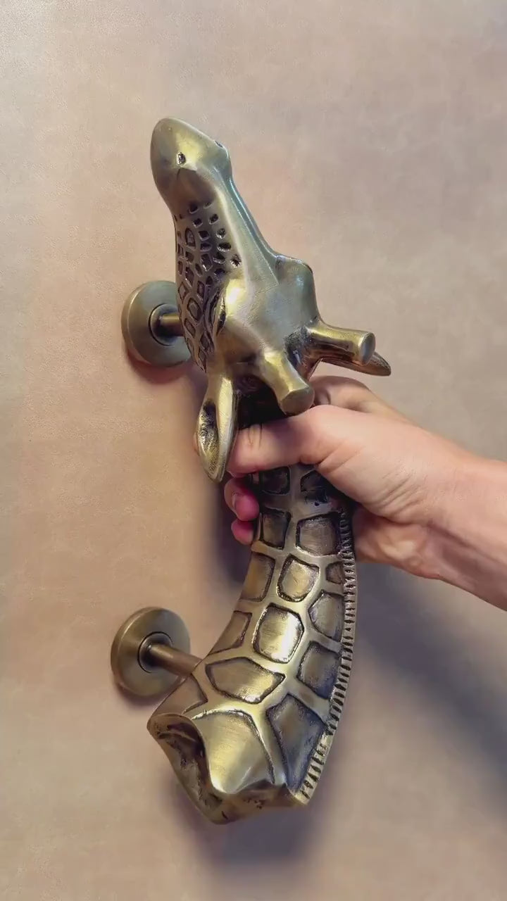 Video of a hand holding the brass giraffe pull